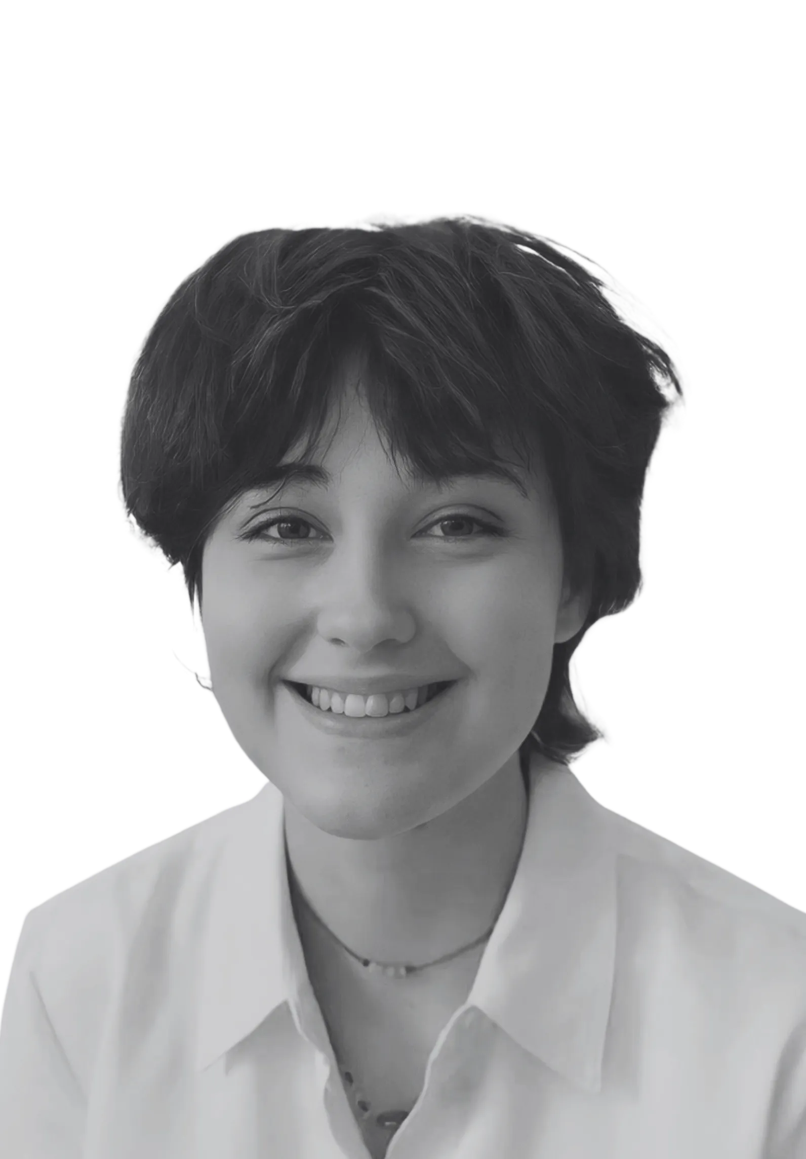 Smiling young person with short dark hair wearing a white collared shirt and a necklace.