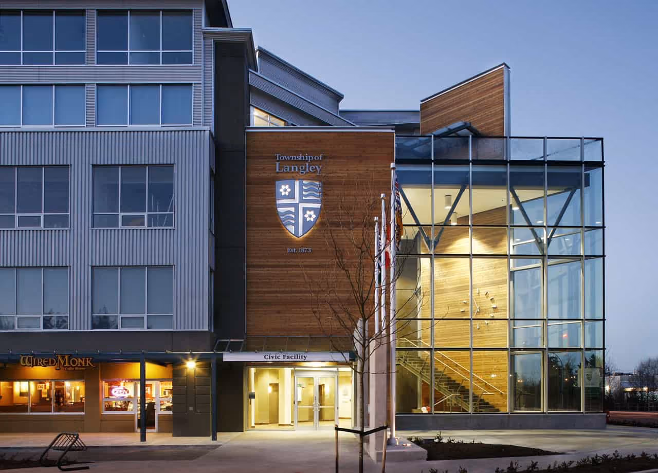 Modern Township of Langley Civic Facility building with glass facade and entrance at dusk.