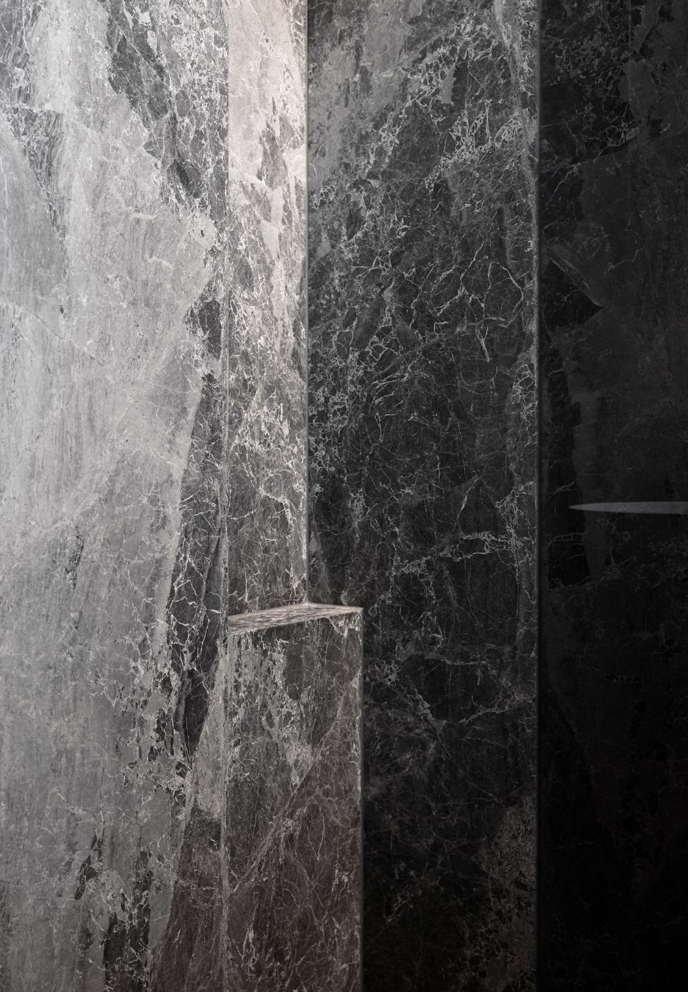 Clifftops Residence bathroom detail with dark natural stone, highlighting dramatic veining and tonal variation.