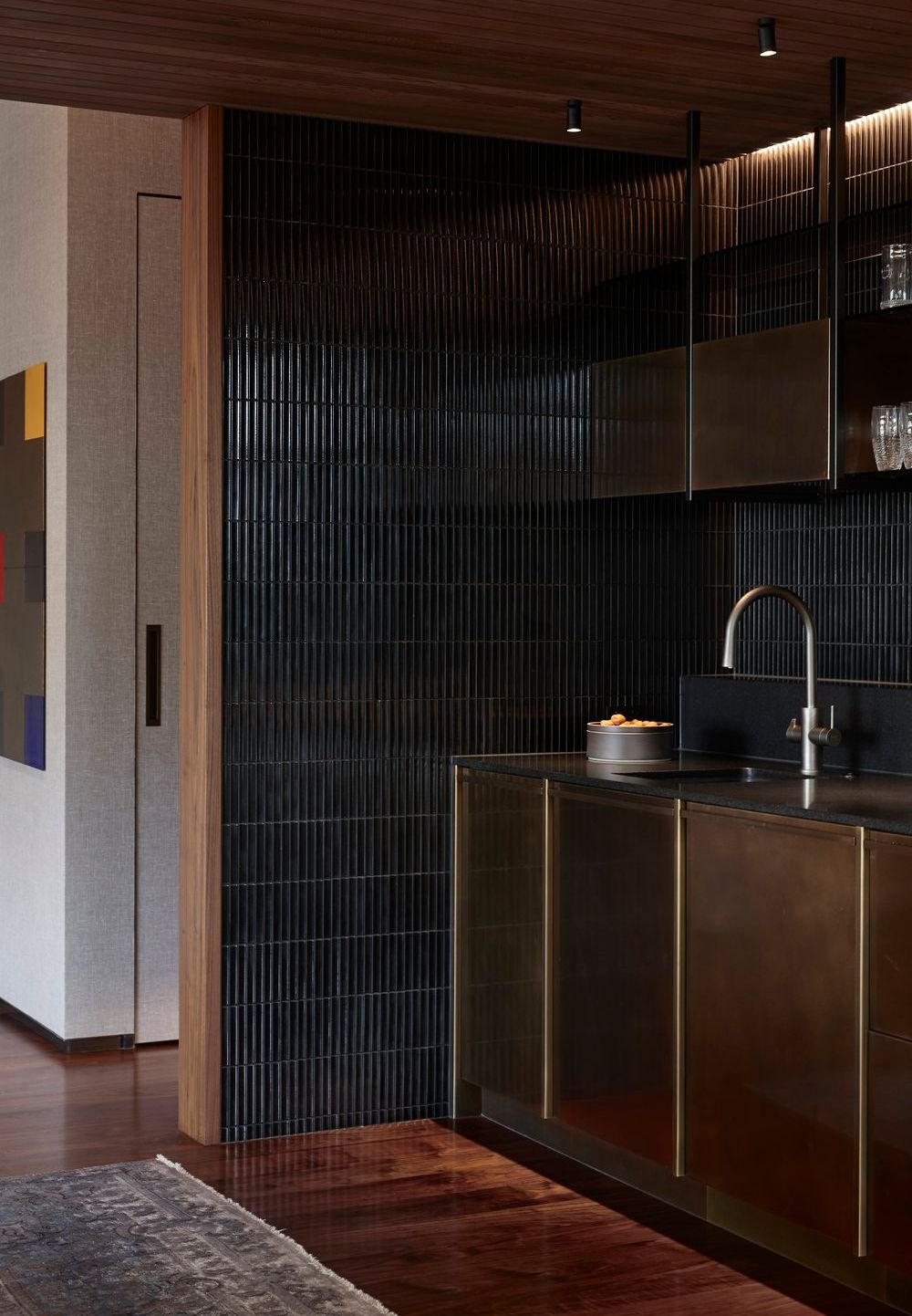 Clifftops Residence joinery with black tiled wall, bronze cabinetry and integrated lighting.