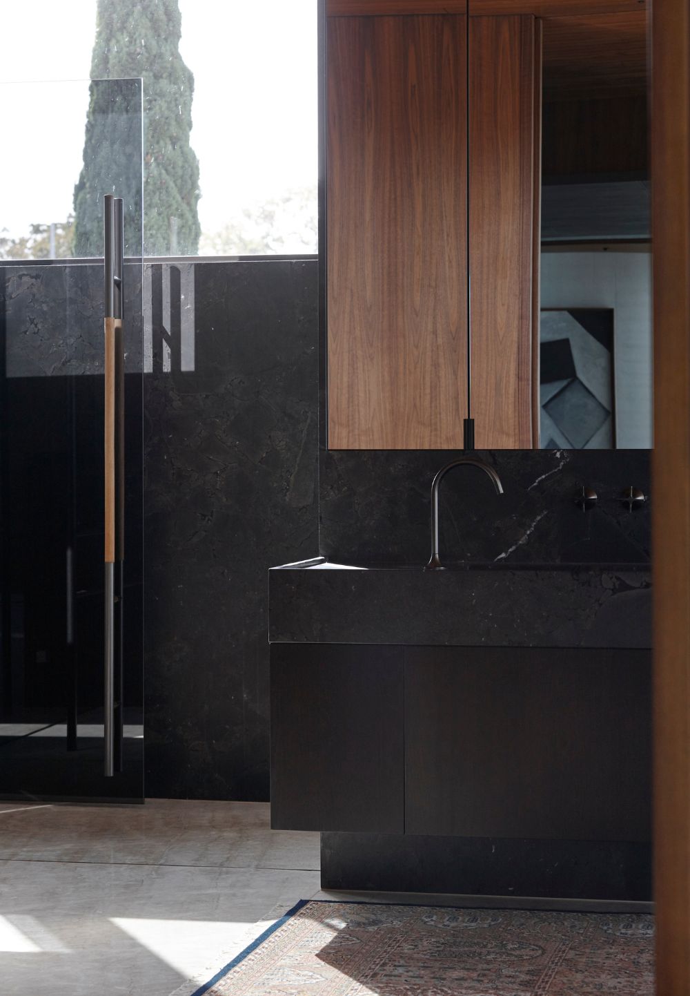 Clifftops Residence bathroom with dark stone vanity, walnut cabinetry and glass shower screen.