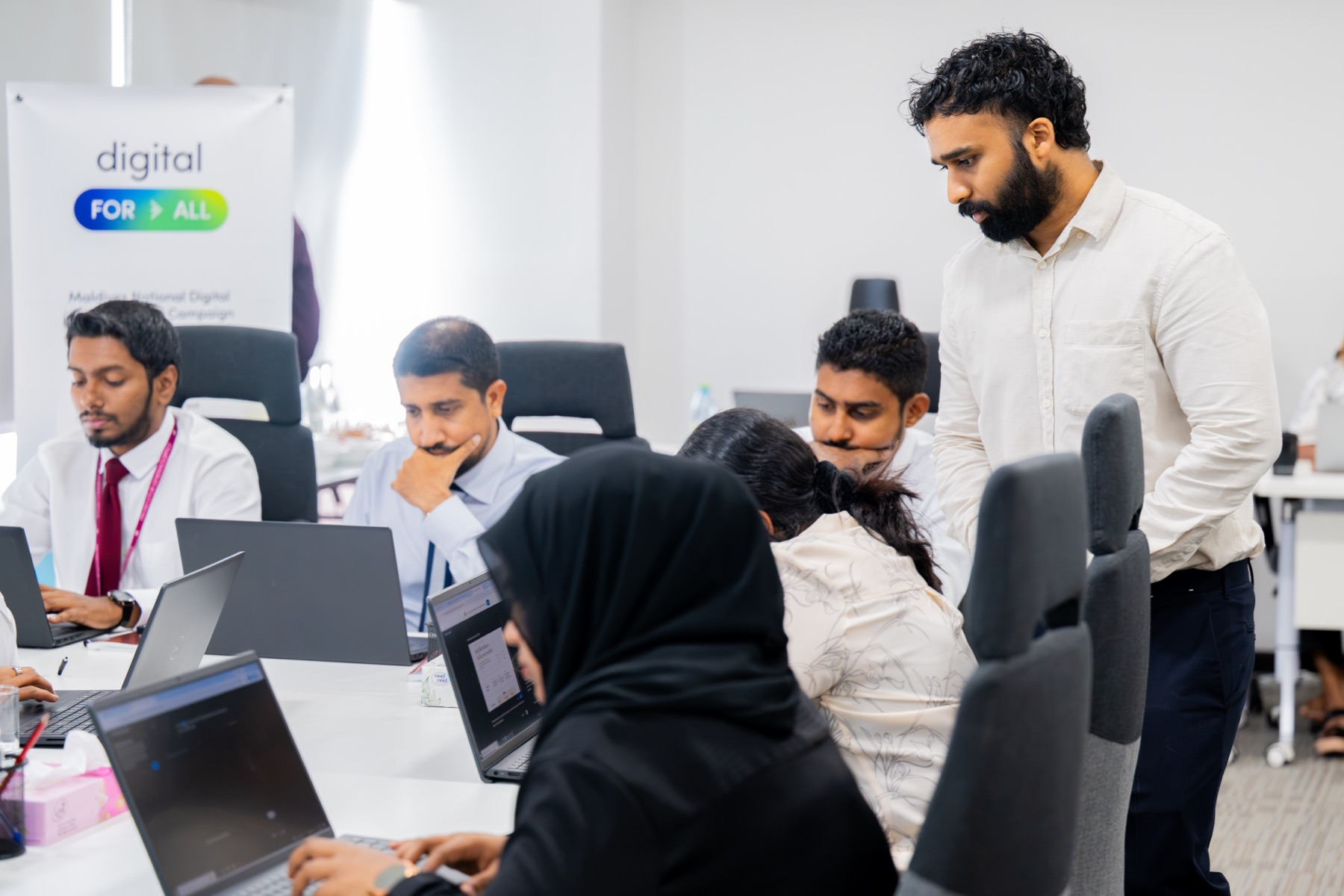Two Future Institute team members working together on a laptop
