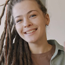 Young girl with dreadlocks making presentation sitting table class