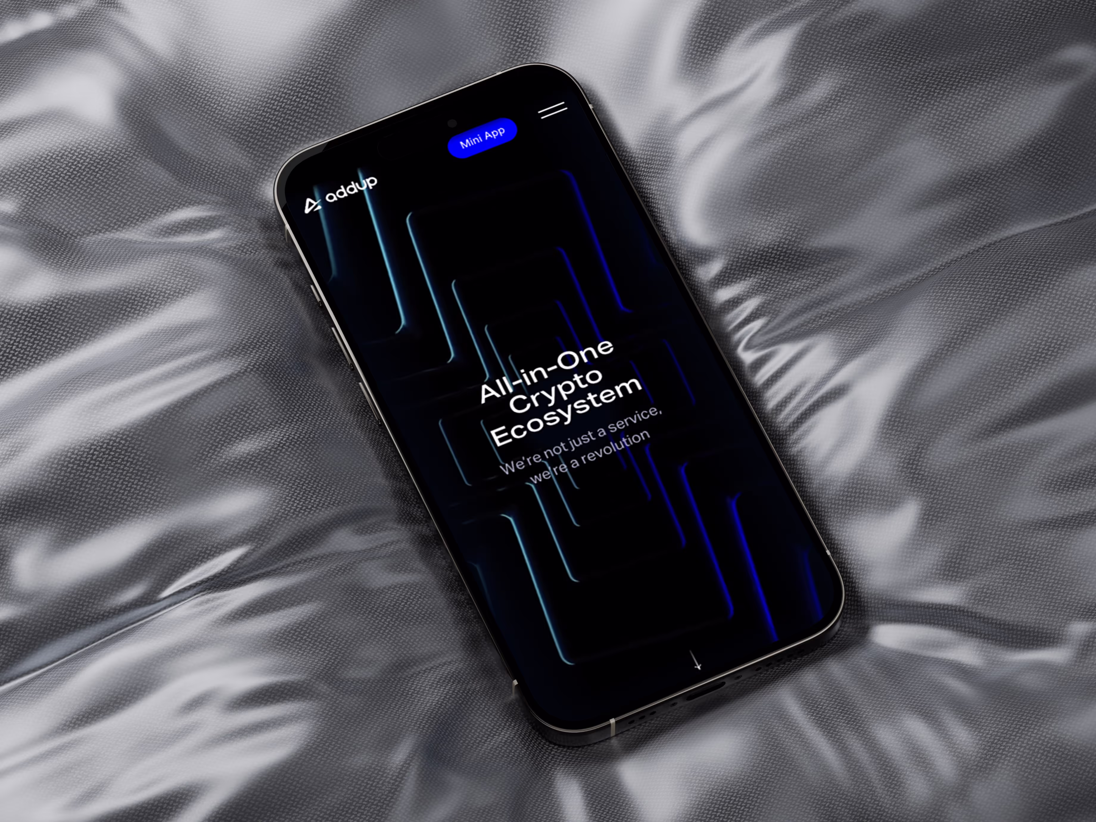 Smartphone lying on a textured, shiny silver-gray fabric with a screen displaying the text 'All-in-One Crypto Ecosystem' and a logo reading 'addup'.