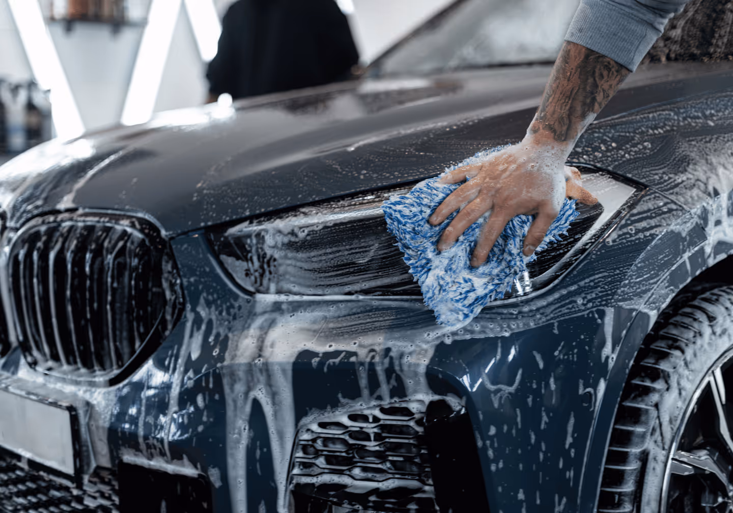 Ein BMW wird gründlich am Scheinwerfer gewaschen. Bei der Fahrzeugaufbereitung Autowaschbär in Reinfeld.
