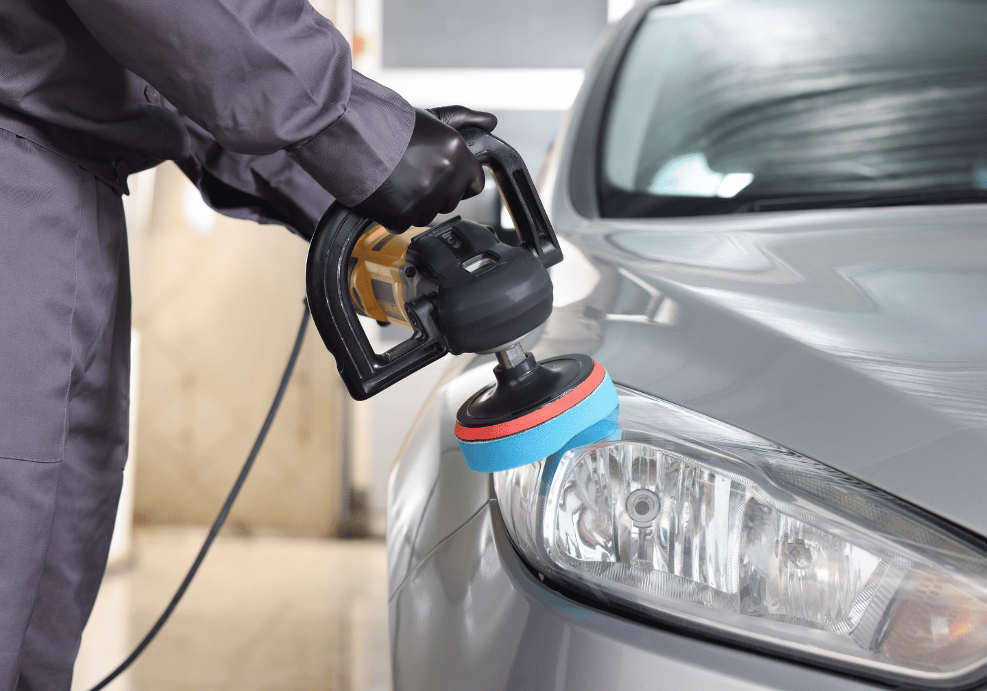 Silbernes Fahrzeug wird mit Poliermaschine poliert. 