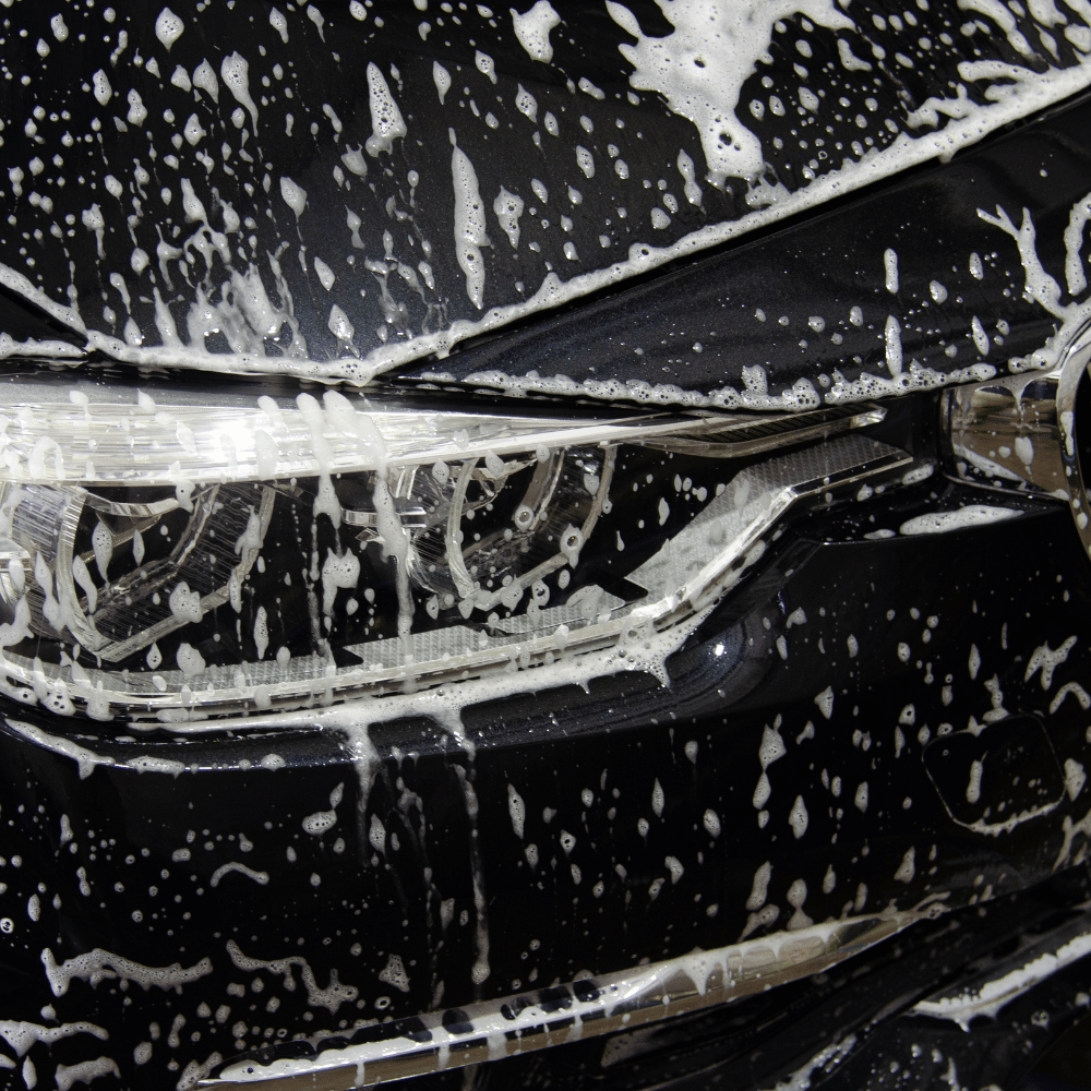 Schwarzer BMW voller Seife wird gewaschen und professionell gereinigt. 