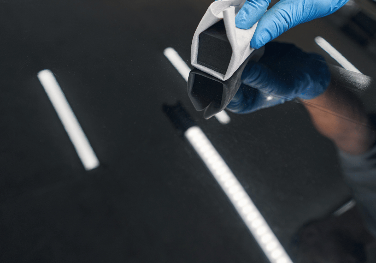 Eine professionelle Keramikversiegelung auf einem schwarzen Auto.