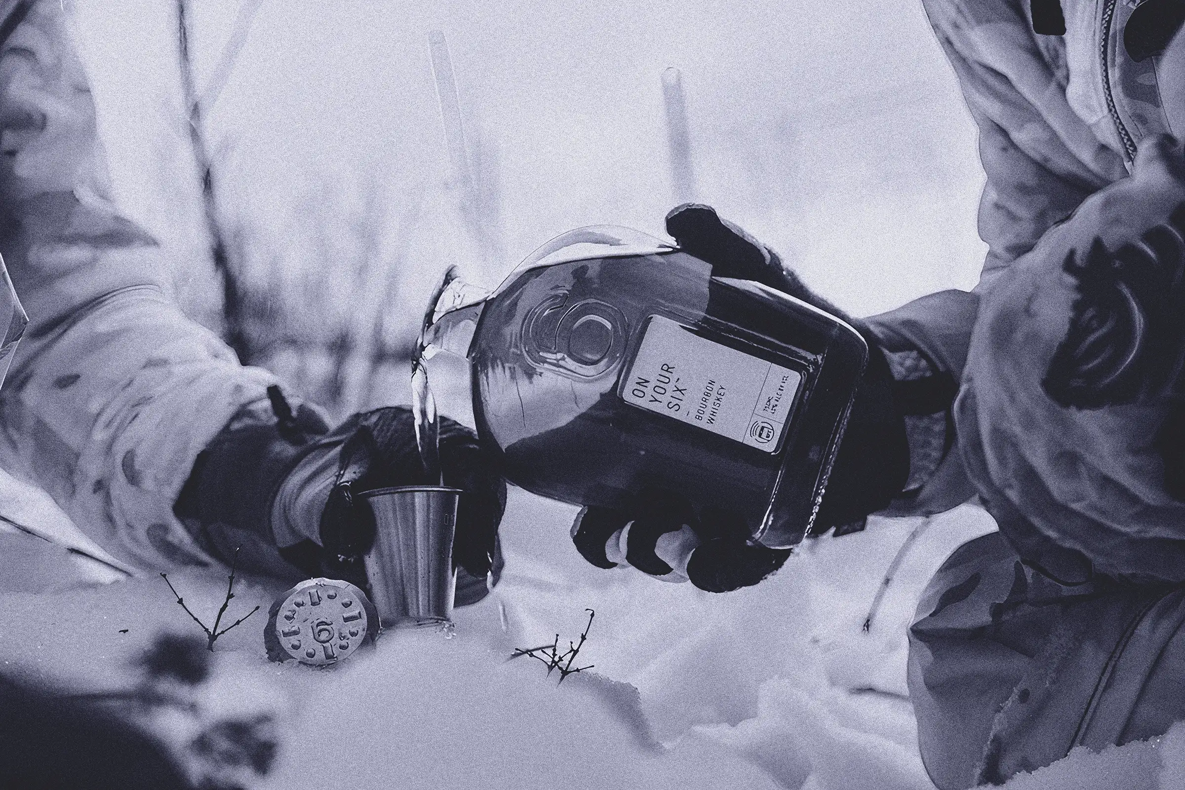 A man pouring a drink from a bottle into a cup.
