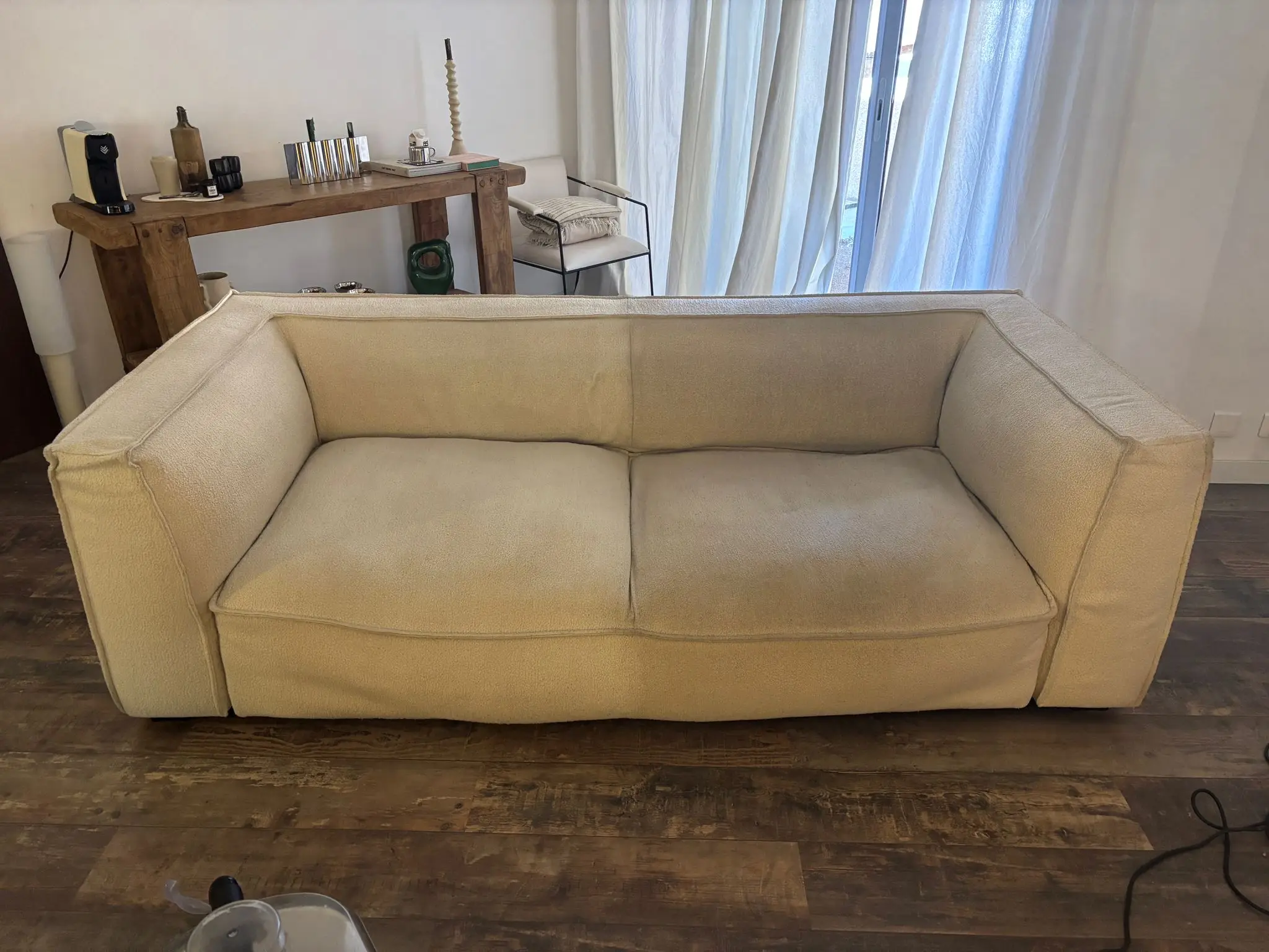 Avant/après nettoyage d’un canapé textile : une moitié sale de poussière avant intervention, l'autre moitié propre