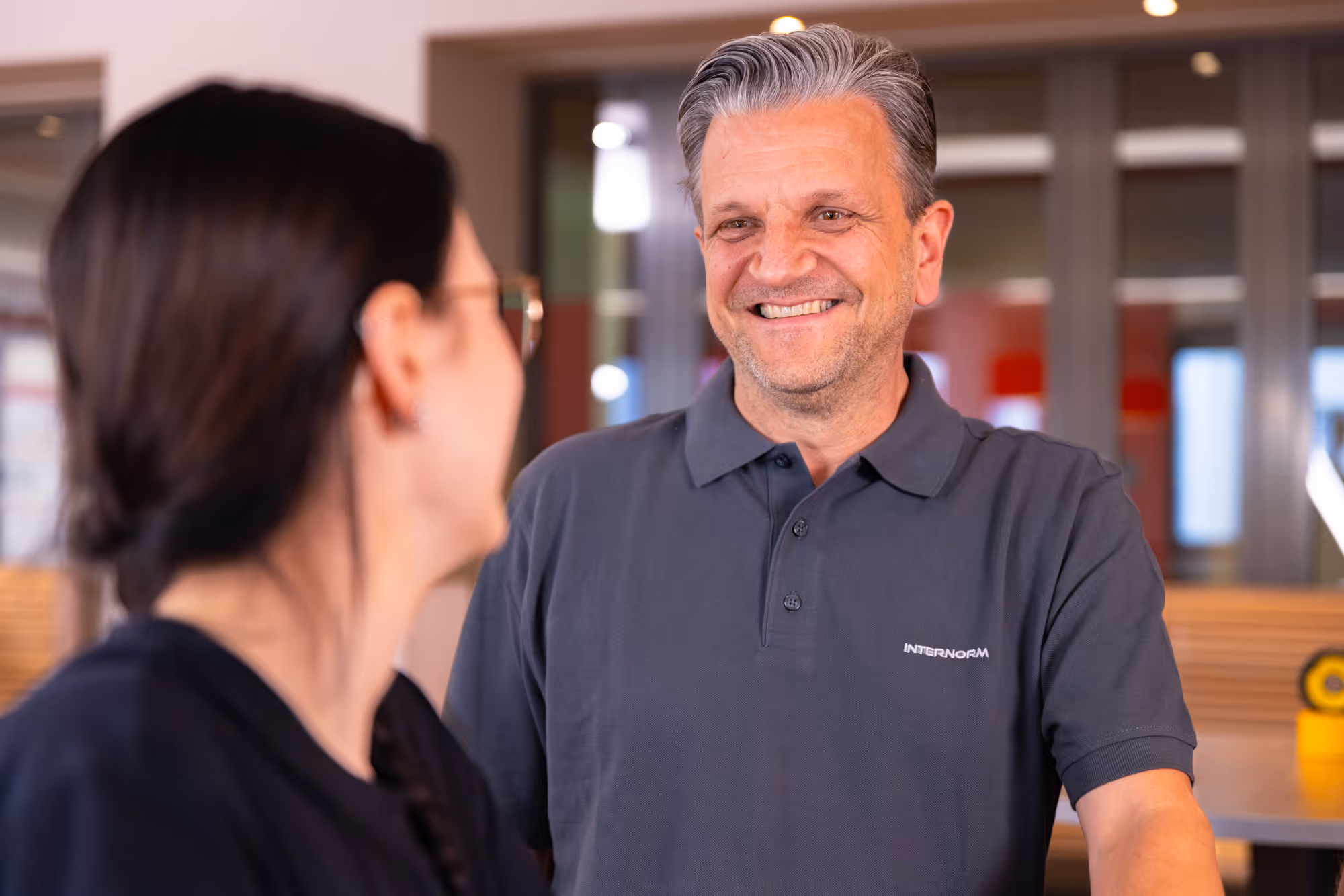 2 Kollegen unterhalten sich miteinander und lachen 