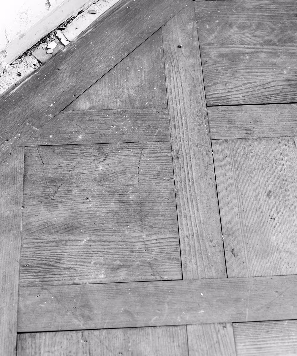 Nahaufnahme eines alten Parkettbodens aus Holz mit sichtbaren Fugen und Gebrauchsspuren.