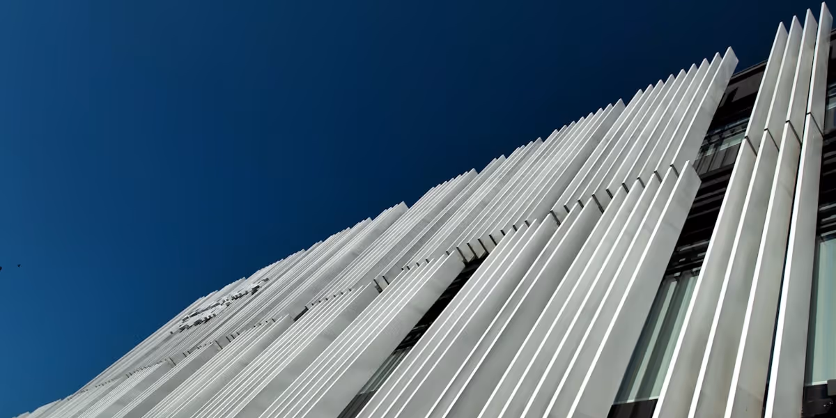 A black-and-white image of metal tubes arranged in rows, varying in size, creating an abstract pattern.