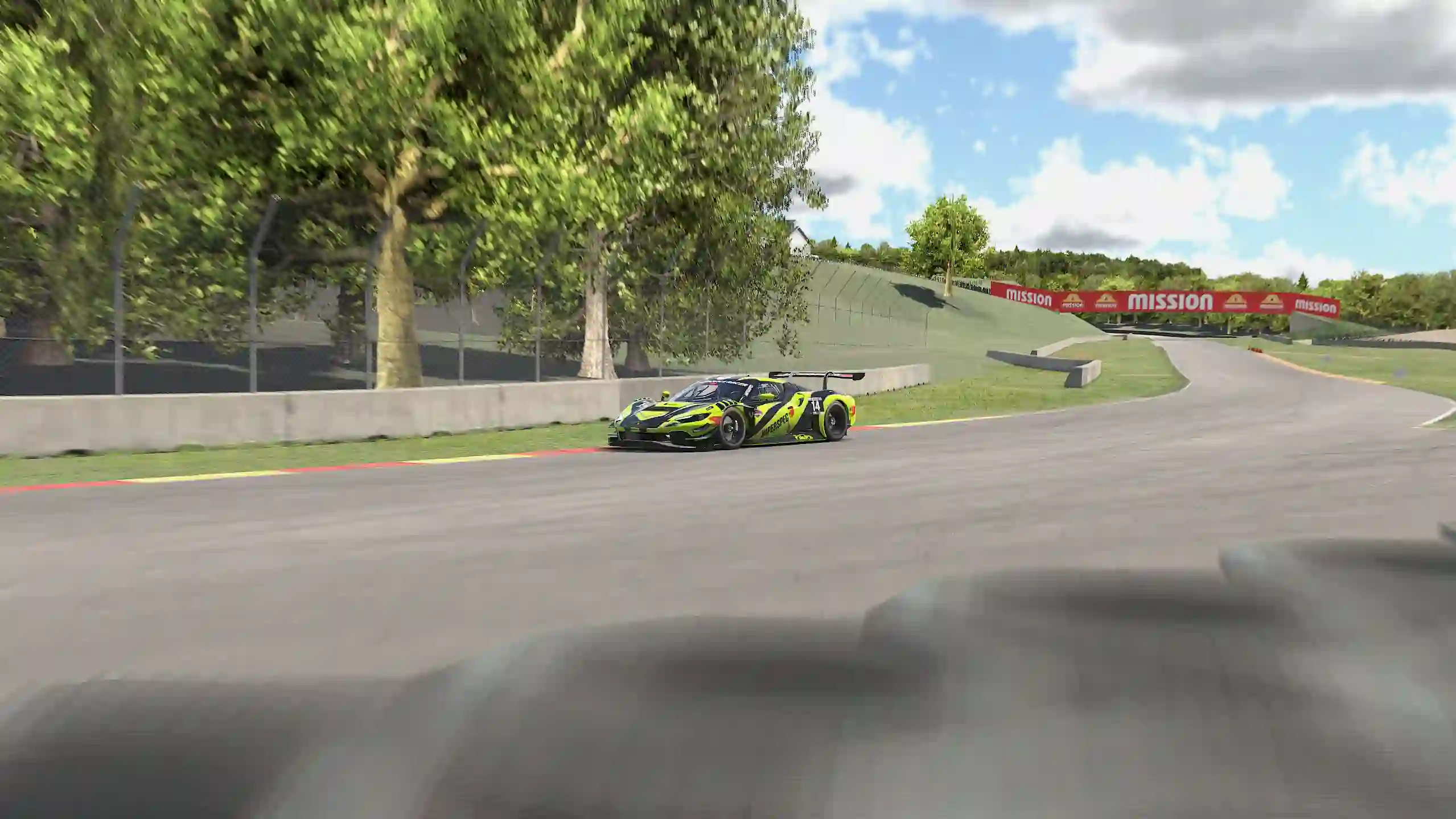 The Ferrari 296 GT3 speeding around a corner at Road America on iRacing.