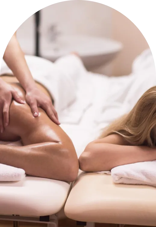 Woman lying face down on spa bed receiving a shoulder massage.