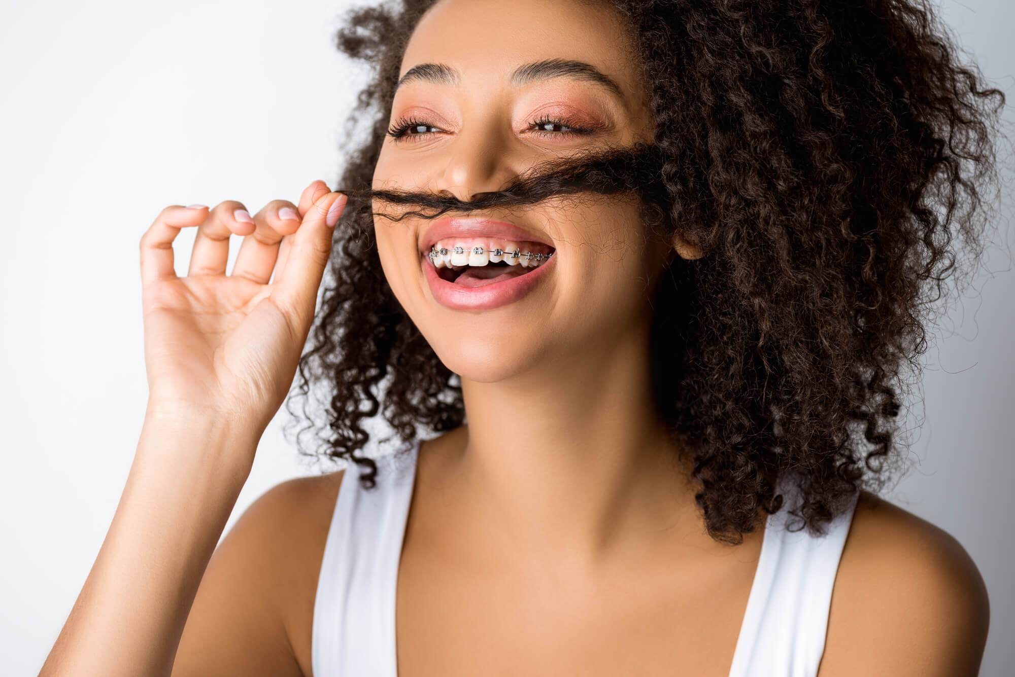 woman smiling after getting braces with an Orthodontist in Little Italy