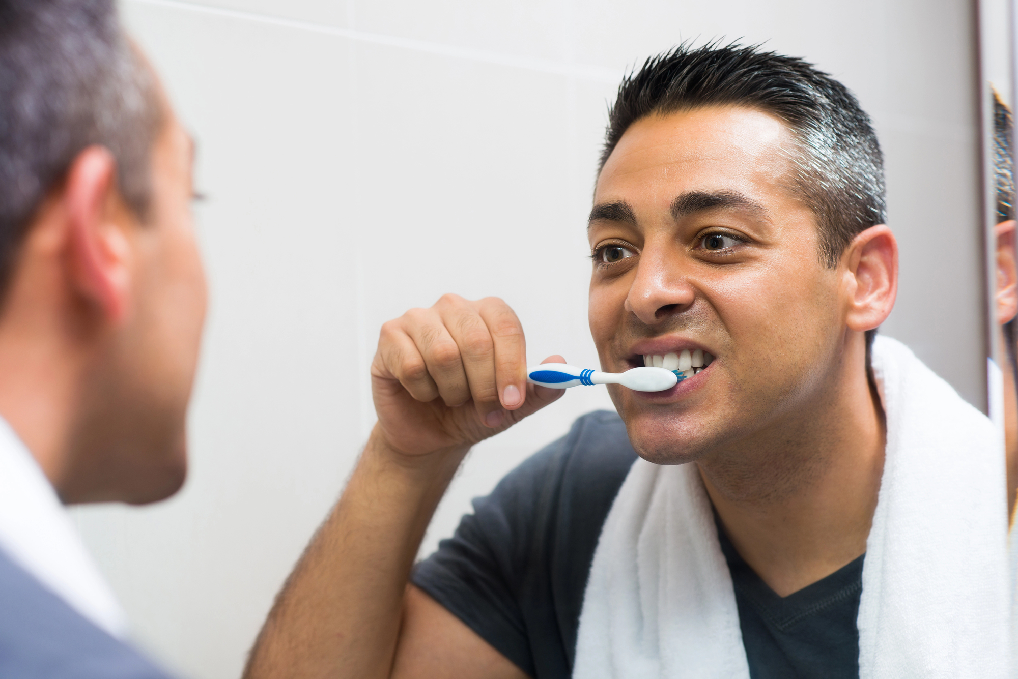 man brushing his teeth after getting implant in bronx