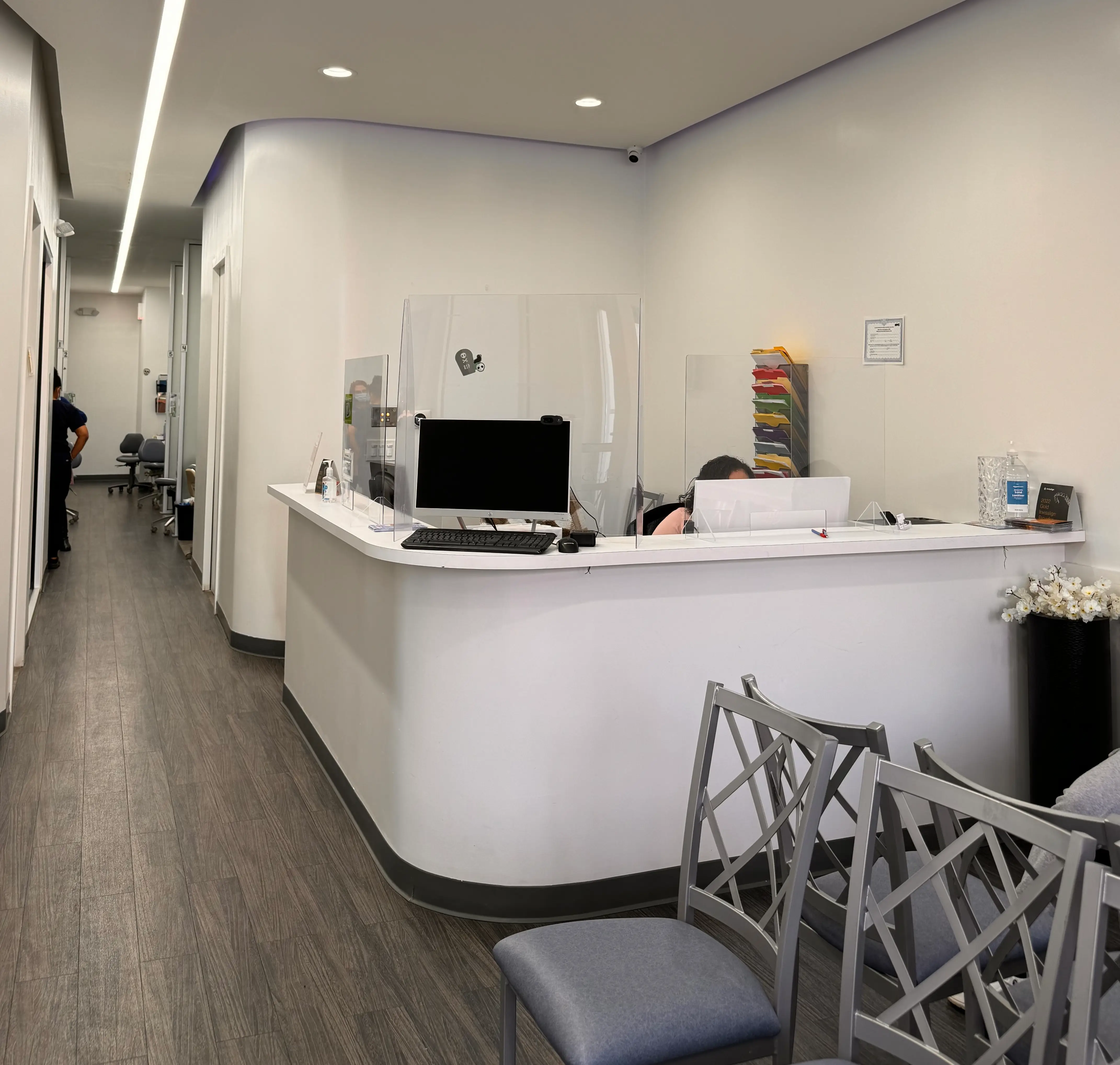 a person sitting behind a desk in a dental office