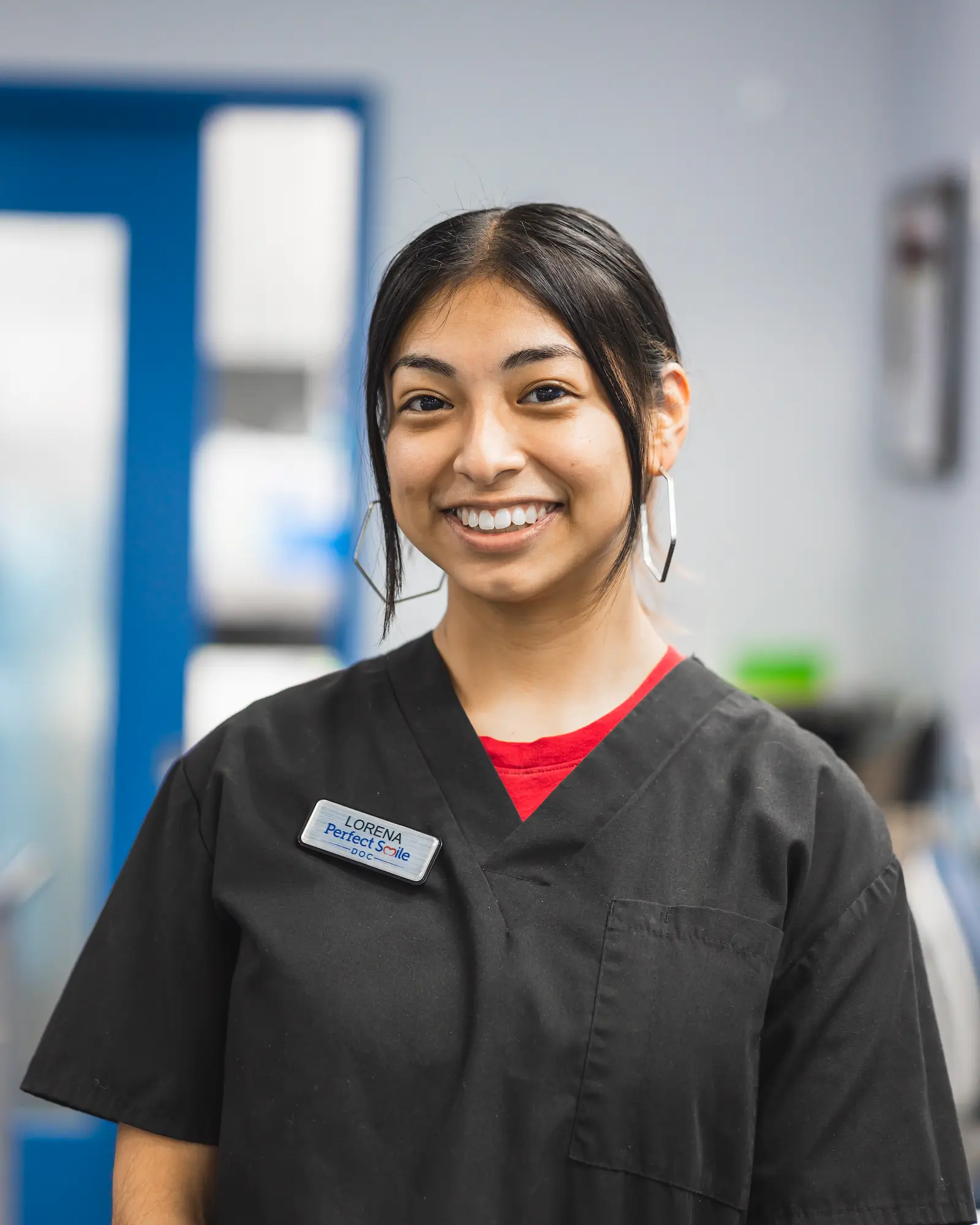 a woman in a black scrub top smiles at the camera