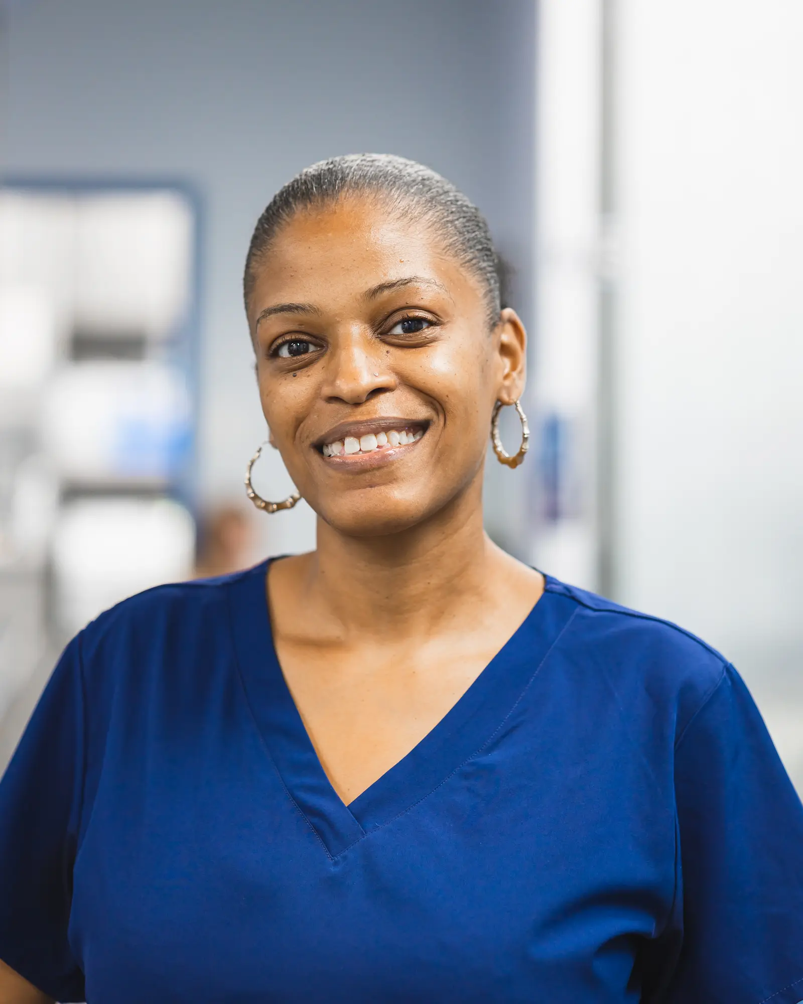 a woman in a blue shirt smiles at the camera