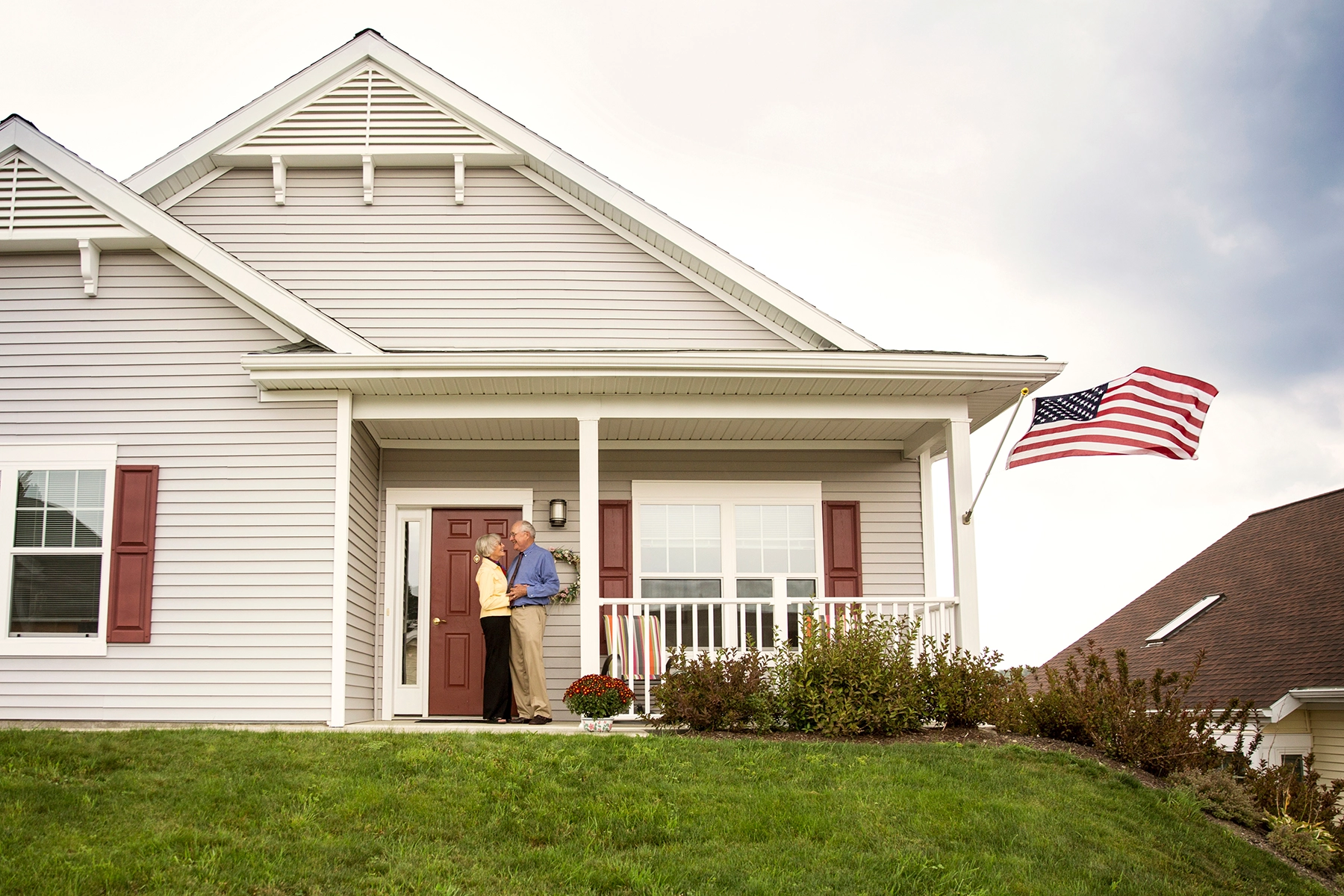 Smiling senior couple standing in front of their home, representing Peak Pro Home Services’ senior-focused home modifications and maintenance support.