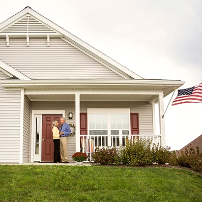 Smiling senior couple standing in front of their home, representing Peak Pro Home Services’ senior-focused home modifications and maintenance support.