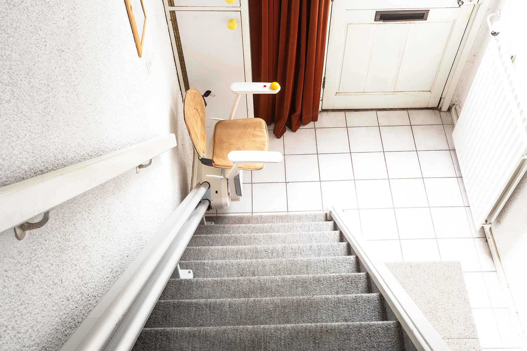 A motorized stair lift installed on an indoor staircase, showing a common accessibility solution provided by Peak Pro Home Services for seniors aging in place in Yakima.