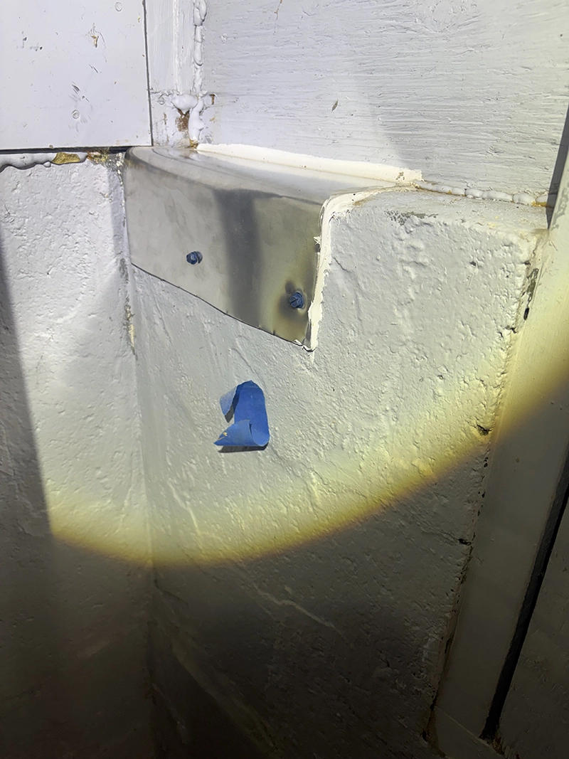 Brick wall penetration sealed with a stainless steel plate and professional caulking to prevent rodent access.