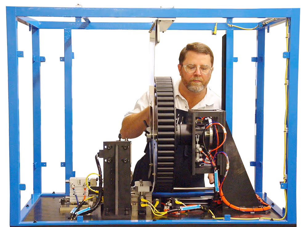 An AeroSpec engineer examining the internal components of an automated machine in the process of assembly.