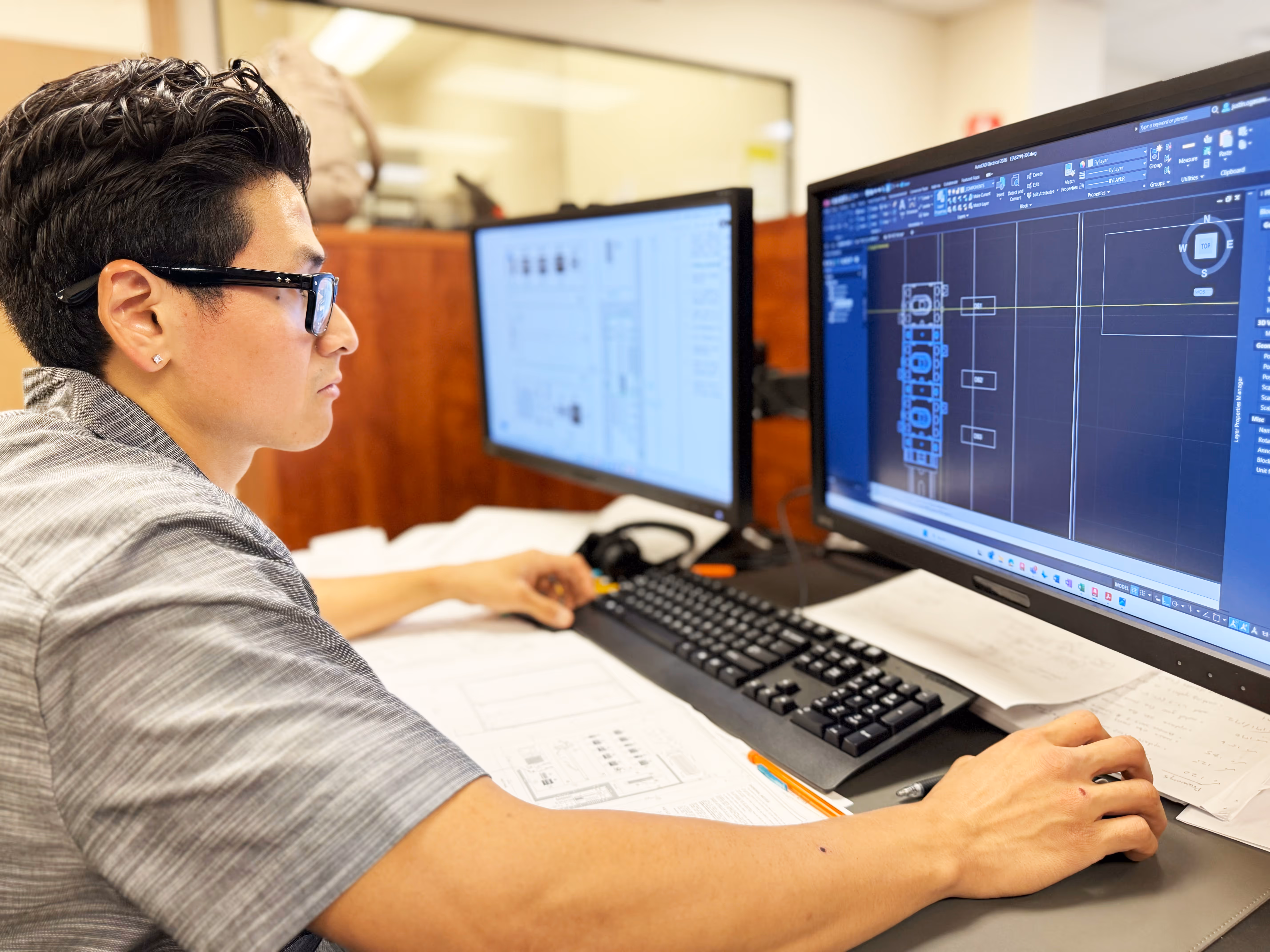 Controls electrical engineer programming and configuring automation systems at a computer workstation.