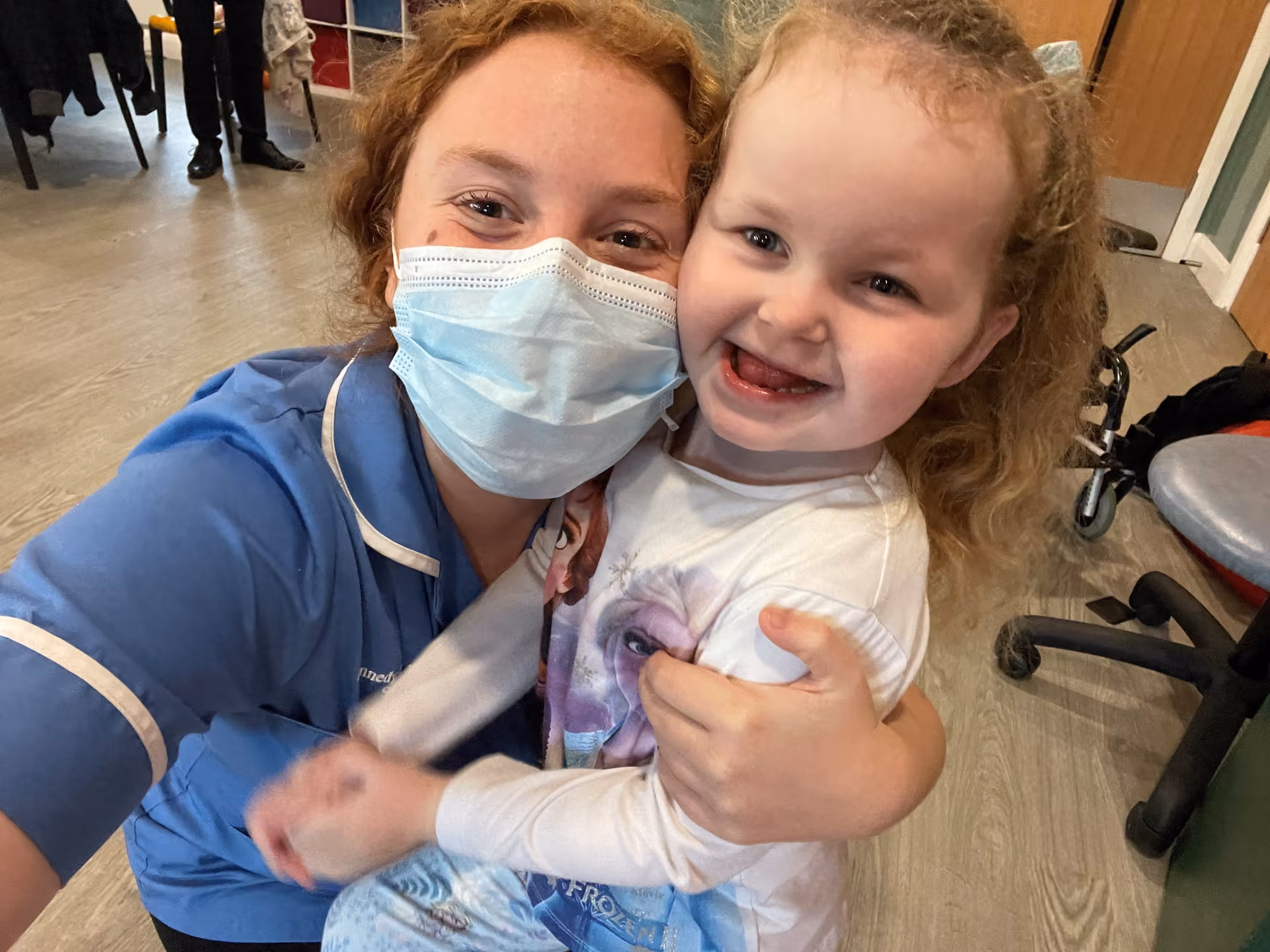 A Rebecca House nurse hugging a smiling child