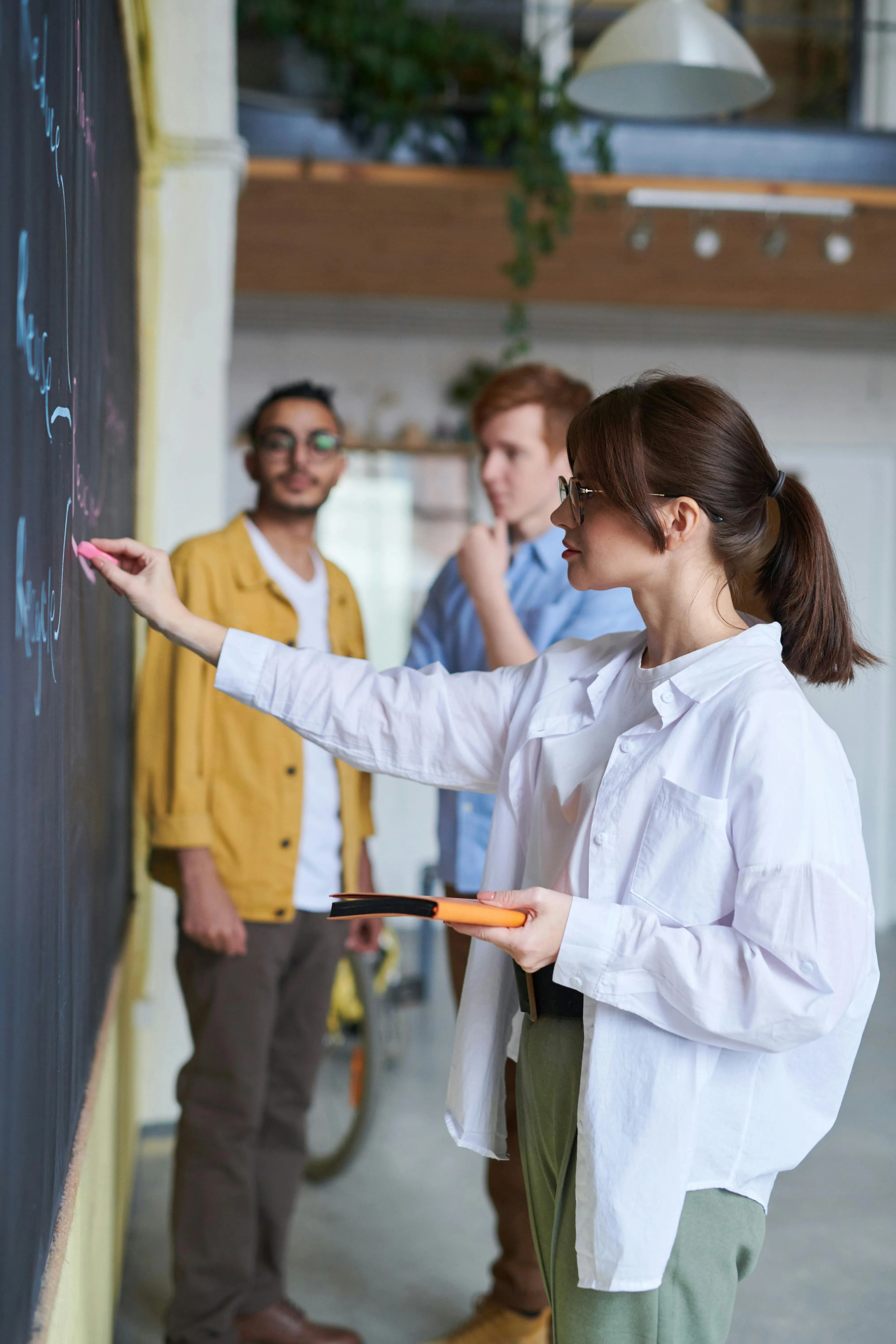 The girl is writing on the chalkboard