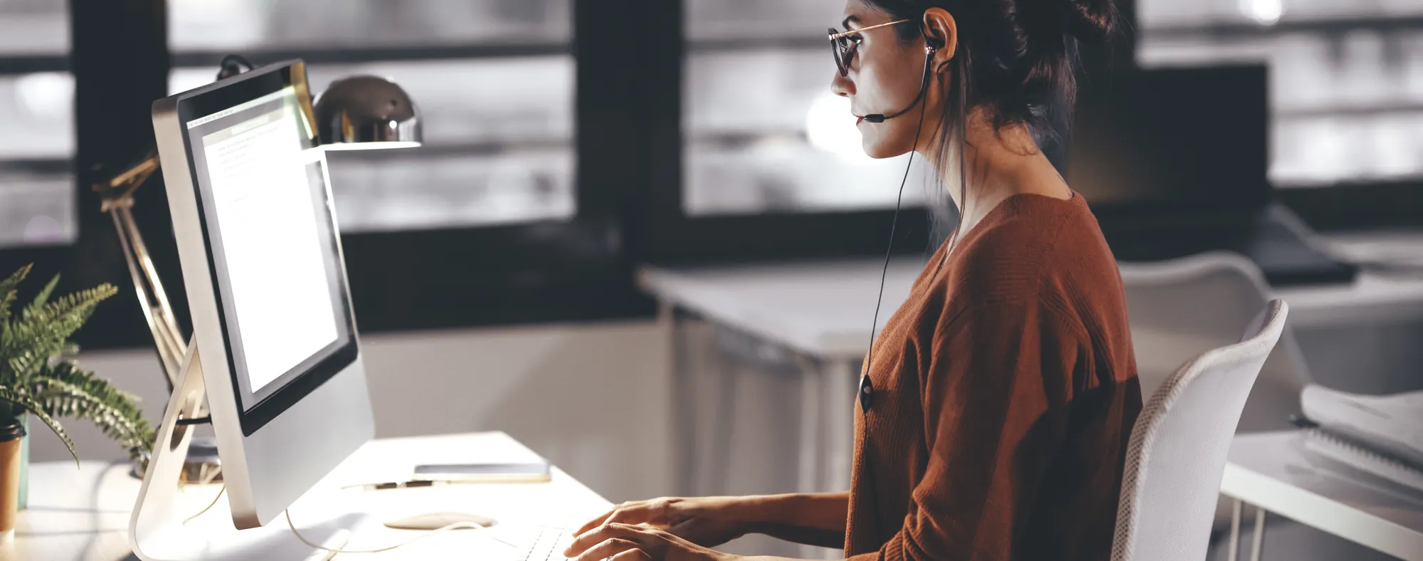 Airline planner with a headset working on a schedule at her desk