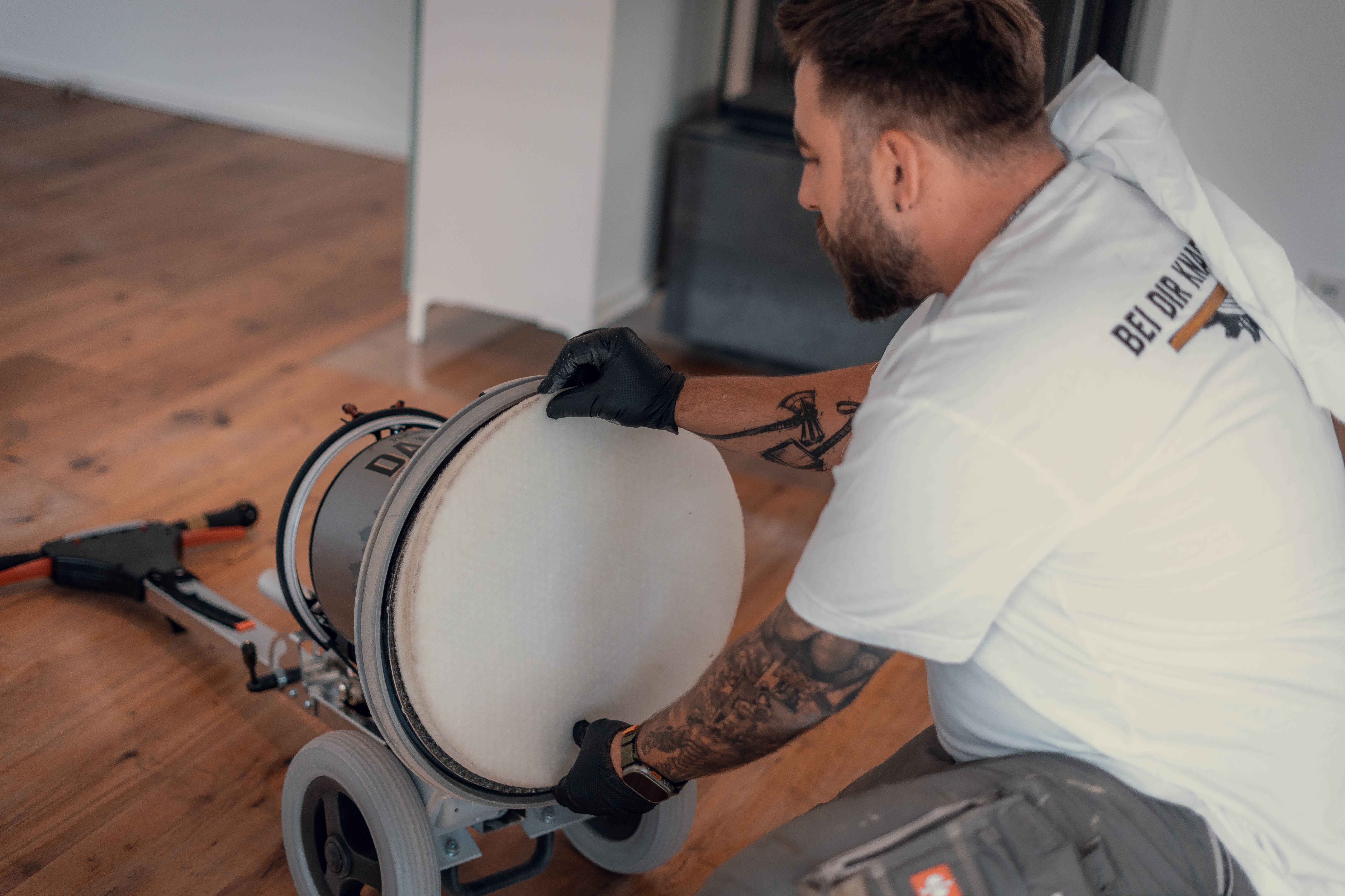 Vorbereitung zur Parkettpflege: Mitarbeiter wechselt das Schleifpad an der professionellen Poliermaschine