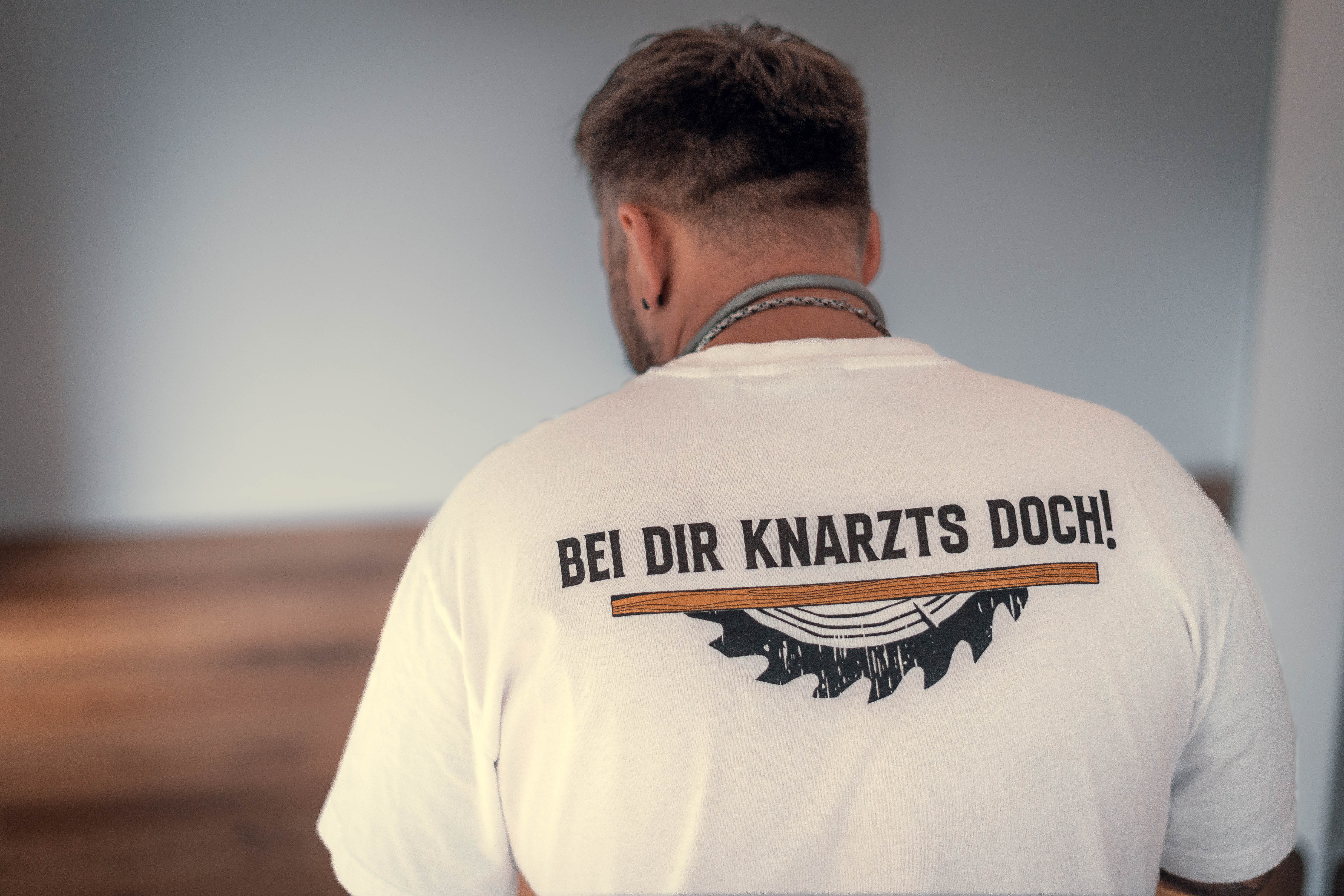 T-Shirt mit Aufschrift "BEI DIR KNARZTS DOCH!", Fachmann bei der Reparatur von knarrenden Parkettböden in Sandhausen.
