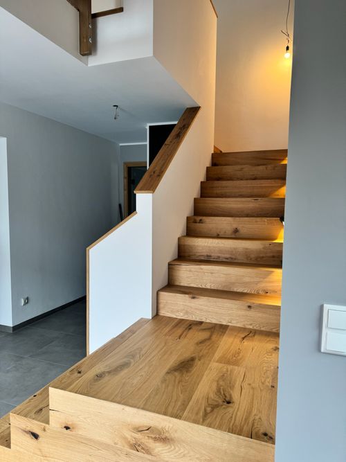 Moderne Treppenrenovierung einer offenen Holztreppe in Kombination mit weißem Geländer