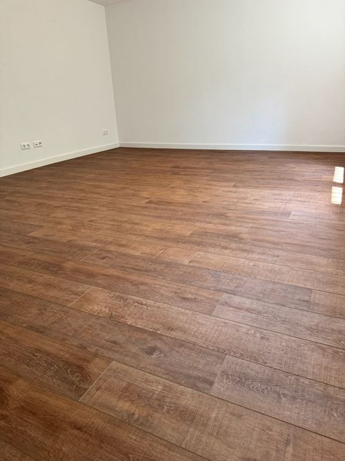 Moderner, dunkler Parkettboden (Dielen-Optik) von Damian Parkett & Boden, verlegt in einem klaren Raum.