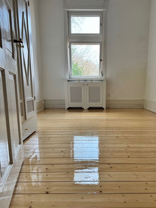 Perfekt veredelter Boden: Extrem glänzendes, geöltes Parkett aus breiten Dielen, verlegt und behandelt von Damian Parkett & Boden.