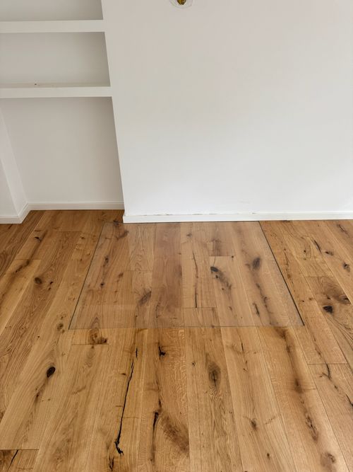 Rustikale Landhausdielen mit deutlicher Maserung und Astlöchern, verlegt von Damian Parkett & Boden, Nahaufnahme der Oberfläche.