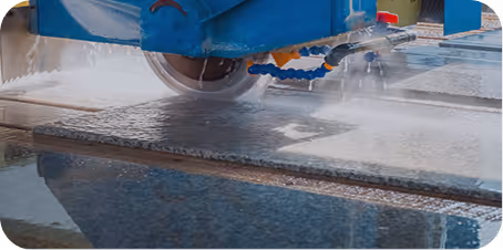 Wasserkühler schneidet eine Granitplatte mit einer rotierenden Säge in einer Steinbearbeitungswerkstatt.