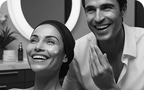 Smiling woman and man applying skincare cream in a bathroom.