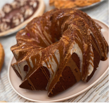 Bundt cake with cinnamon glaze and icing on a white plate.