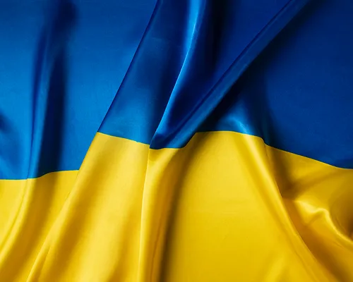 Close-up of a wrinkled flag with blue on top and yellow on the bottom.