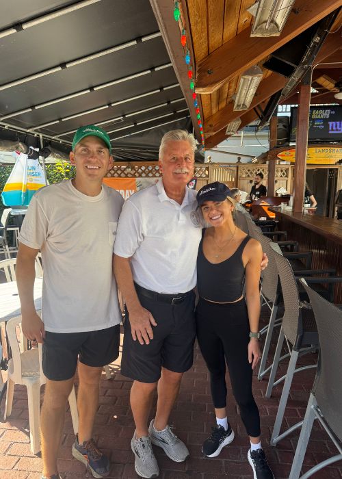 3 coworkers in a brick office with books in the background 