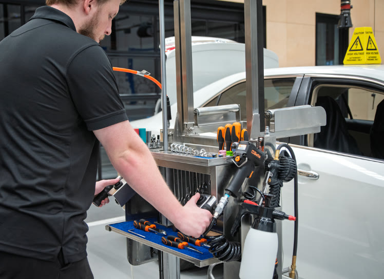 Technician using the ES Trolley beside a vehicle