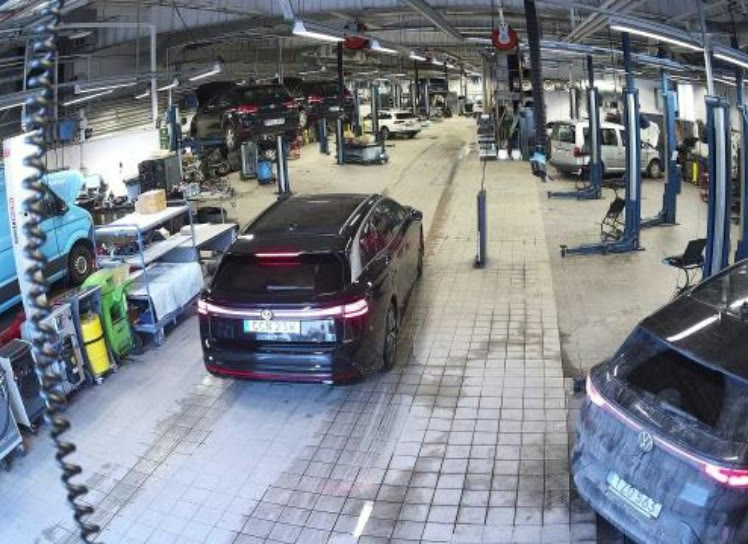 Vehicle entering an inspection lane in a busy workshop