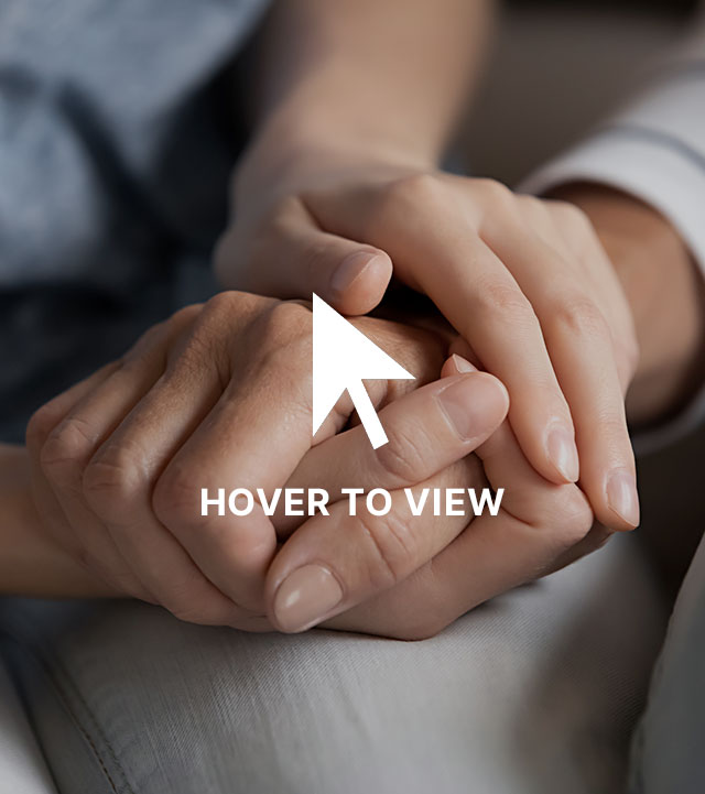 Close-up of two pairs of hands gently holding each other, symbolizing care and support.