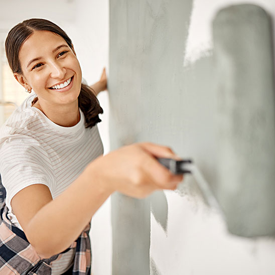 Person using an orange cordless drill to install or fix a door lock.