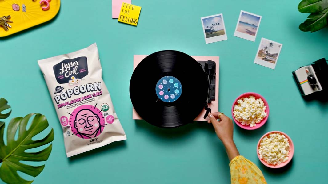 Custom-built tabletop food video production setup featuring Lesser Evil popcorn, vinyl record player, and colorful lifestyle props — cinematic food and beverage brand content produced by Big River Film Co.