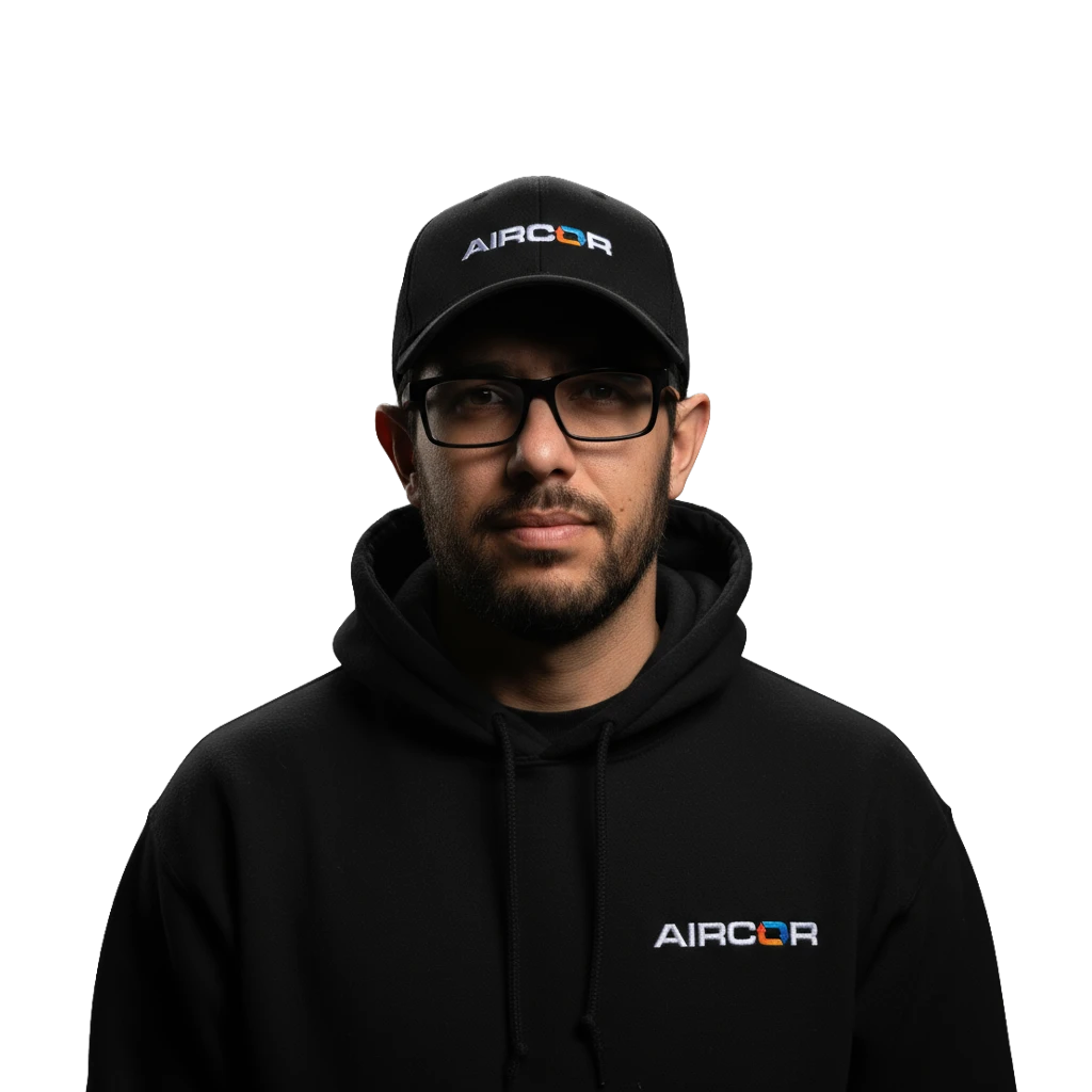 Man wearing black Aircor cap and black hoodie with Aircor logo, glasses, and trimmed beard.